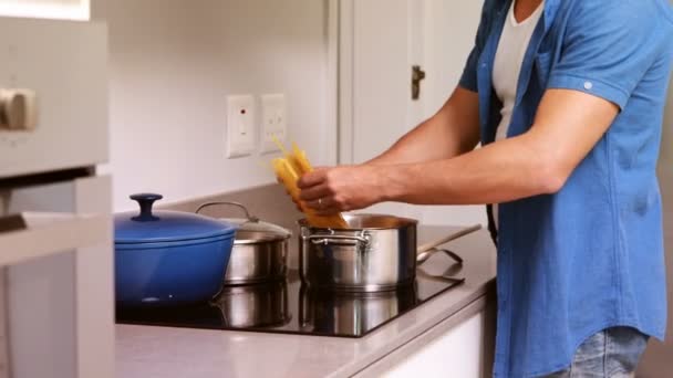 Hombre poniendo pasta en una sartén — Vídeo de stock