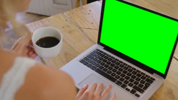 Blondin med laptop i köket — Stockvideo