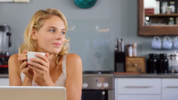 Blonde using laptop in kitchen — Stock Video