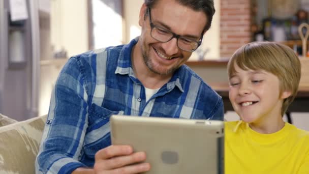 Otec a syn pomocí počítače tablet pc na gauči — Stock video