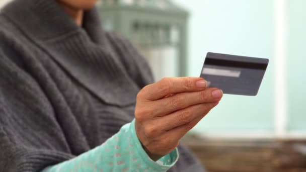Mujer mirando su tarjeta de crédito — Vídeos de Stock