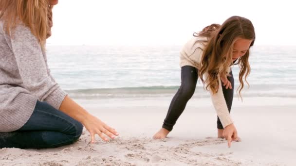 Mère et fille dessinent dans le sable — Video