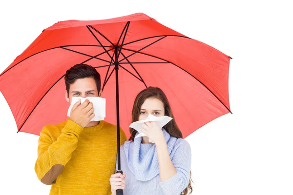 Casal soprando seus narizes sob um guarda-chuva — Fotografia de Stock