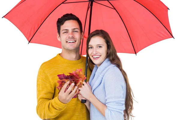 Gelukkige paar onder een paraplu met bladeren — Stockfoto