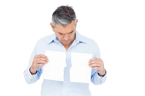 Homem segurando rasgado papel branco — Fotografia de Stock