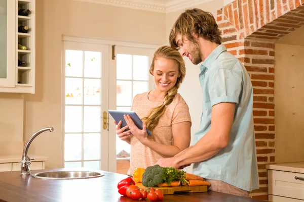 Linda pareja de cocinar y usar la tableta —  Fotos de Stock