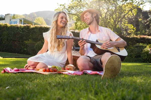 Paar met een picknick en gitaar spelen — Stockfoto