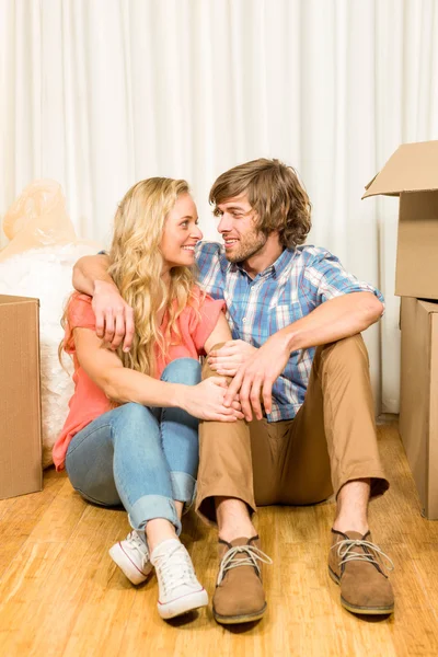 Feliz casal sentado no chão — Fotografia de Stock