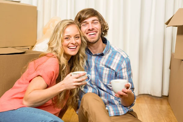 Paar zittend op de vloer terwijl het drinken — Stockfoto