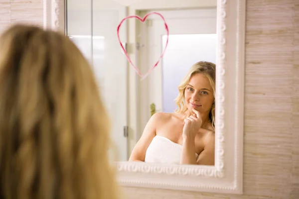 Rubia mirando grande corazón en espejo — Foto de Stock