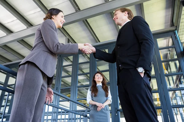 Empresário apertando as mãos com empresária — Fotografia de Stock