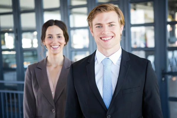 Businessman and businesswoman smiling  in office — Stock Photo, Image