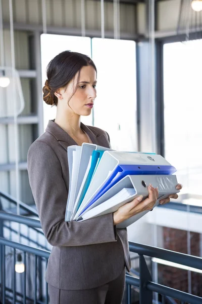 Businesswoman carrying stack of folders — Stock Photo, Image