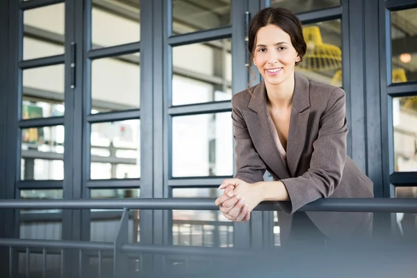 Jeune femme d'affaires adossée à des balustrades — Photo