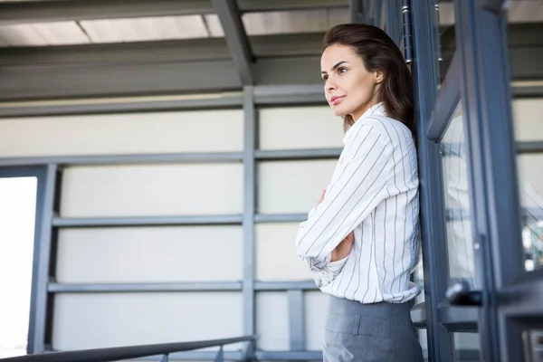 Businesswoman young leaning on office door — Stock Photo, Image