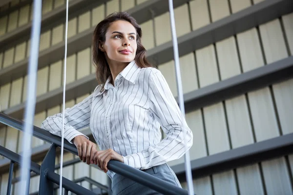 Geschäftsfrau steht an einem Geländer — Stockfoto