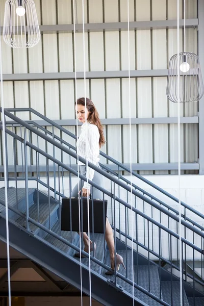 Businesswoman climbing staircase in office — Stock Photo, Image