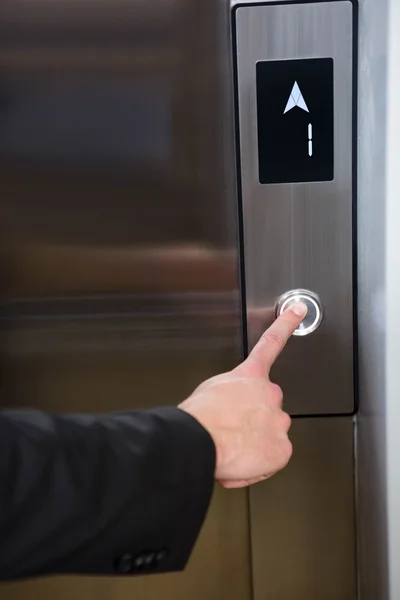 Businessman pressing elevator button — Stock Photo, Image