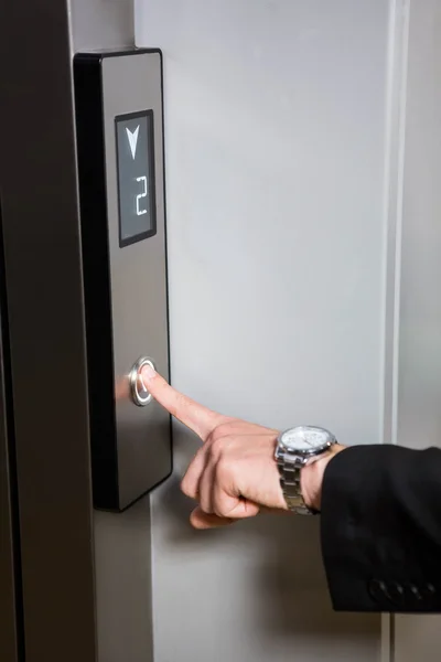 Бизнесмен нажимает кнопку лифта — стоковое фото