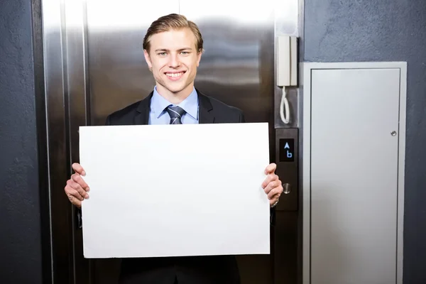 Businessman holding a signboard — Stock Photo, Image