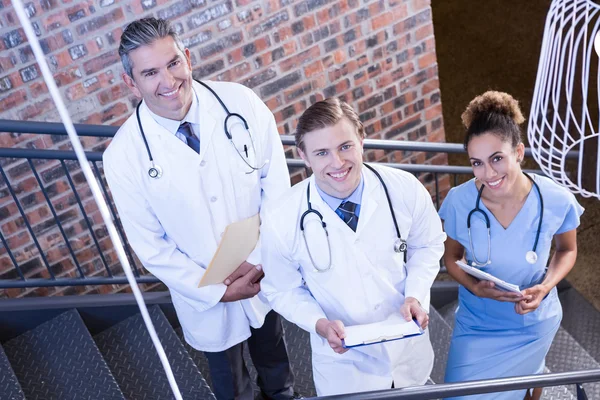Doctors standing on staircase with document — Stock Photo, Image