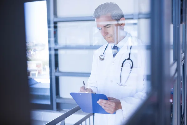 Médico masculino escrevendo na área de transferência — Fotografia de Stock