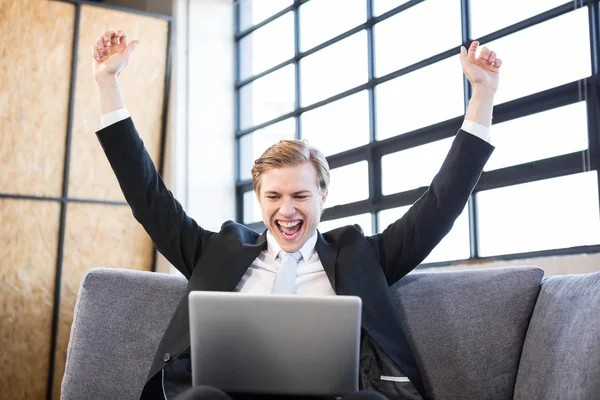 Empresario levantando las manos con emoción delante de la computadora portátil —  Fotos de Stock