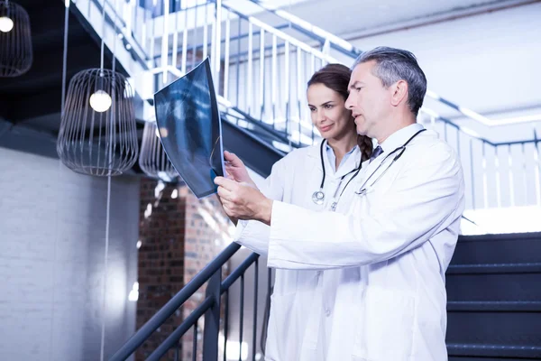 Doctors examining  x report on staircase — Stock Photo, Image