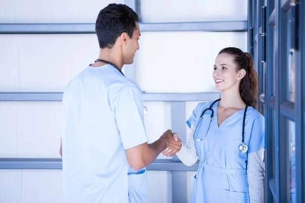 Medici che stringono la mano nel corridoio — Foto Stock