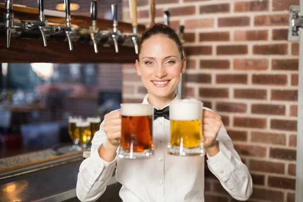Barman segurando duas cervejas — Fotografia de Stock