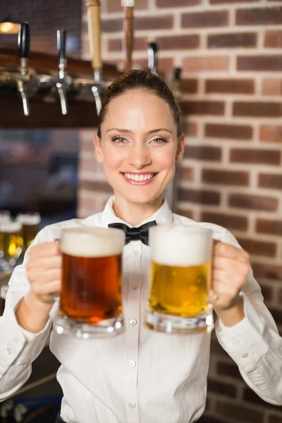 Female bartender holding two beer — Stock Photo, Image