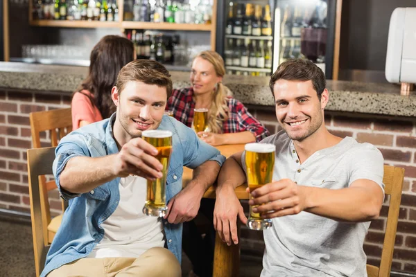 Homens brindam na frente enquanto as mulheres falam — Fotografia de Stock