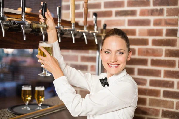 Bardame schenkt Bier ein — Stockfoto