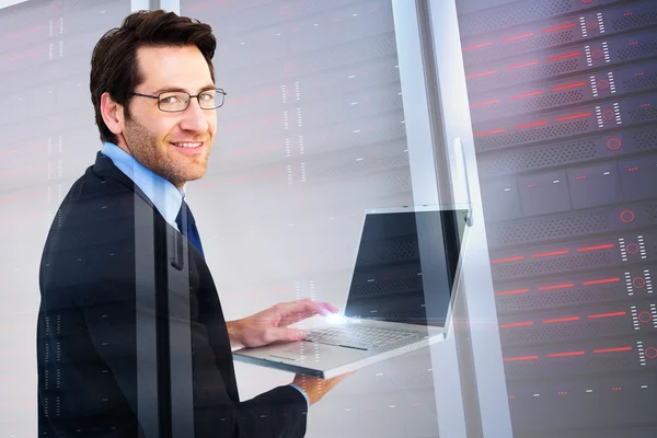 Smiling businessman using a laptop — Stock Photo, Image