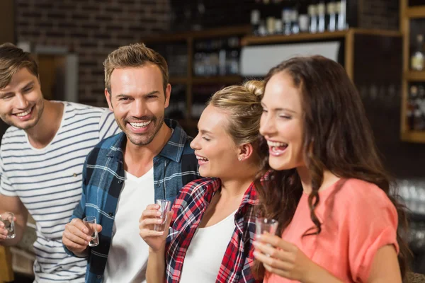 Friends laughing with shot glasses in hand — Stock Photo, Image