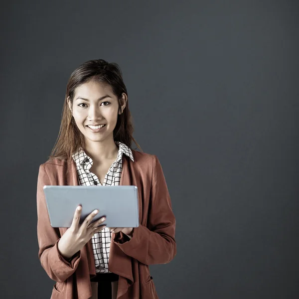 Empresária sorridente usando um tablet — Fotografia de Stock