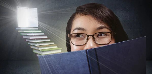 Söt student dölja ansiktet bakom en bok — Stockfoto