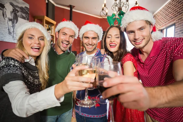 Amici che indossano cappelli di Natale brindare — Foto Stock