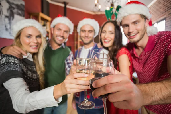 Friends wearing Christmas hats toasting — Stock Photo, Image