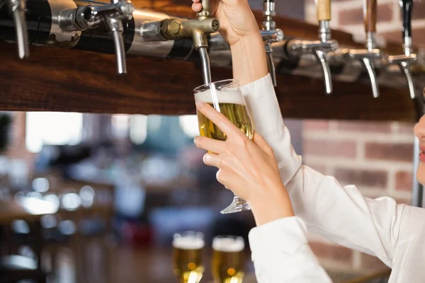 Barmaid derramando cerveja — Fotografia de Stock