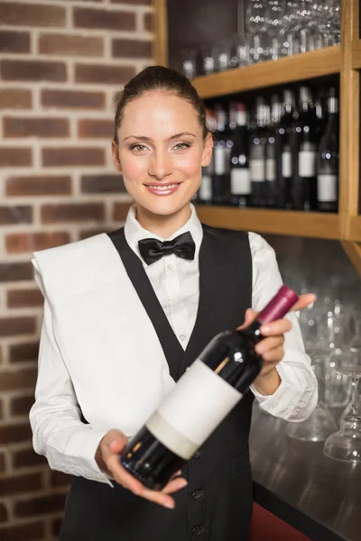 Barmaid tenant une bouteille de vin — Photo