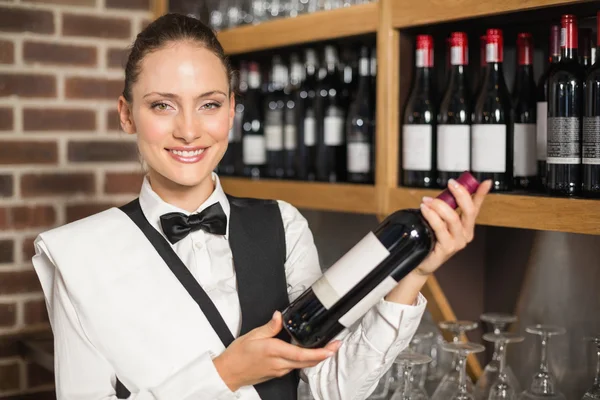Barmanka drží láhev vína — Stock fotografie