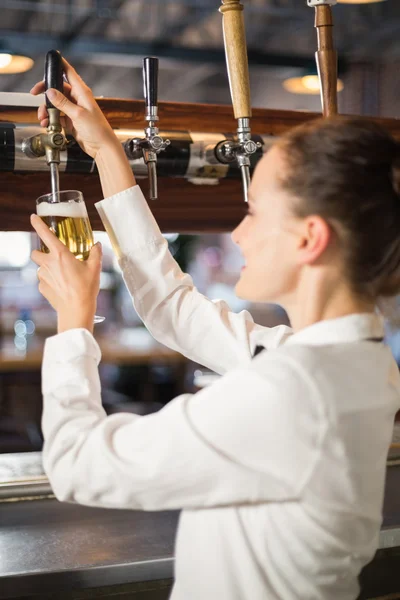 Barflicka hälla en öl i en bar — Stockfoto