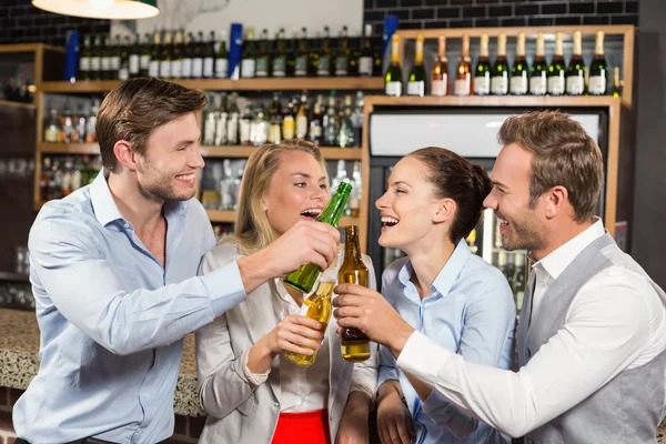 Freunde stoßen mit Flaschen an — Stockfoto