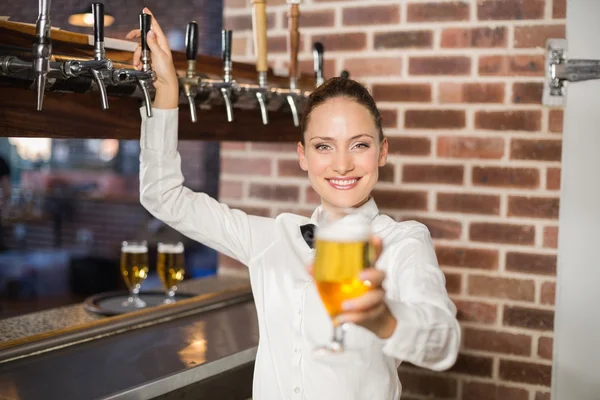 Empregada de bar atraente segurando uma cerveja — Fotografia de Stock