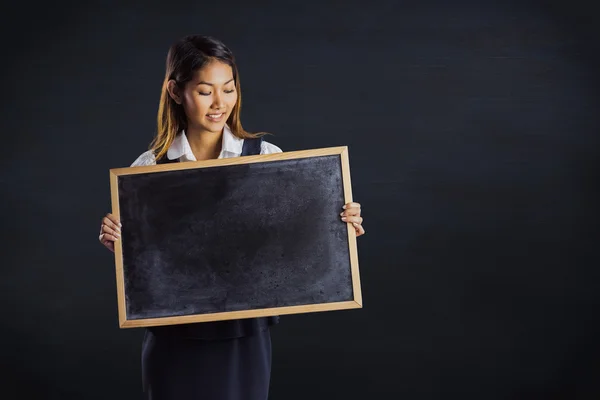 Businesswoman holding a blackboard — Stock Photo, Image