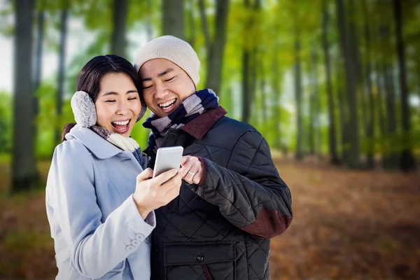 Veselý pár při pohledu na chytrý telefon — Stock fotografie