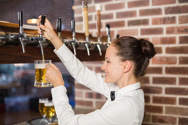 Bardame schenkt Bier ein — Stockfoto