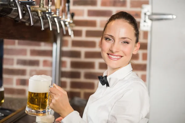 Barmaid segurando cervejas — Fotografia de Stock