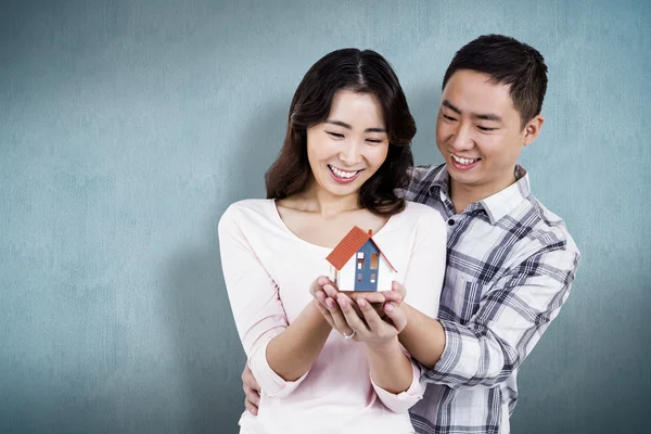 Casal segurando uma casa modelo — Fotografia de Stock